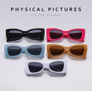 Flat lay of rectangular sunglasses in black, pink, blue, brown, and white colors