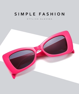 Detail shot of hot pink cat eye sunglasses on white geometric display stand