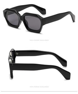 Detail view of black thick-frame polygonal sunglasses with sleek dark lenses and wide temples