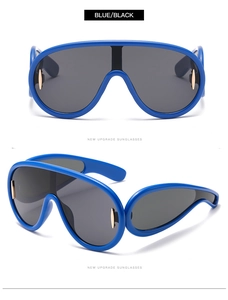 Dettaglio di occhiali da sole blu oversize con finiture dorate e lenti polarizzate