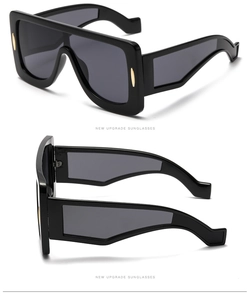 Detail of oversized square sunglasses with wide temples and gold metal accents