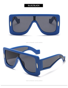 Detail of square oversized royal blue sunglasses with golden metal accents and black lenses