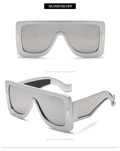 Detail of silver oversized shield sunglasses with metallic gold temples and mirrored lenses