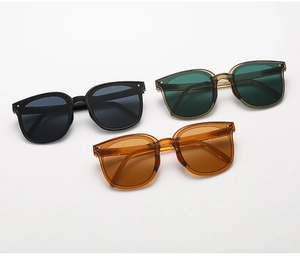 Detailed view of three foldable square sunglasses in black, dark green, and amber frames