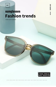 Close-up of translucent olive green folding sunglasses with golden metal hinges