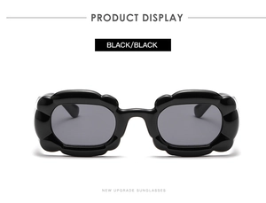 Detail einer schwarzen Sonnenbrille mit unregelmäßig gewellten Fassungen in Blumenform