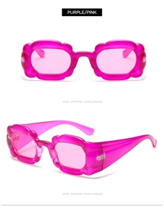 Detail der pinkfarbenen Sonnenbrille in Blütenform mit gewelltem Rahmen im Cat-Eye-Stil