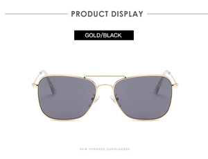 Détail de lunettes de soleil en métal doré avec double pont et verres noirs UV400