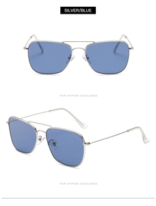 Détail de lunettes aviateur avec monture en métal argenté, verres bleus et double pont