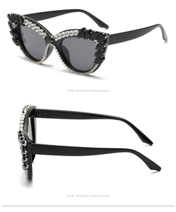 Detail view of black cat-eye sunglasses with luxury rhinestone inlay and dark grey lenses