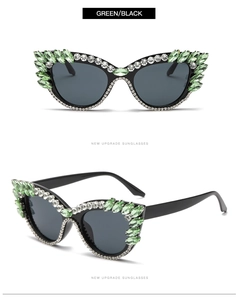 Close-up of cat-eye sunglasses featuring green rhinestones and dark lenses on black frames