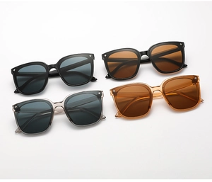 Détail de lunettes de soleil carrées noires, grises et ambre avec rivets en étoile