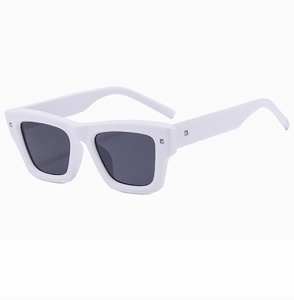 Close-up of white square sunglasses frame with silver rivets and dark UV lenses