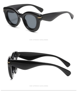 Detail of glossy black cat-eye frame sunglasses with stylish golden metal temple accents