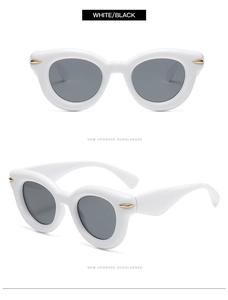 Detail of vintage thick white frames and dark grey lenses with golden metal accents