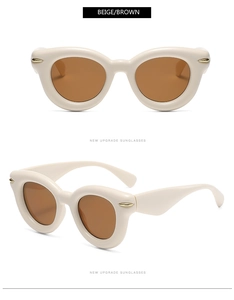 Macro detail of beige thick oval frame sunglasses with golden metallic streamline temple