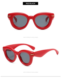 Macro view of red chunky cat-eye sunglasses featuring golden arrow metal accents
