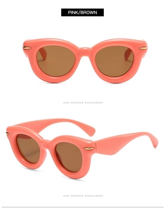 Macro detail of thick pink frames and brown lenses on retro oval sunglasses