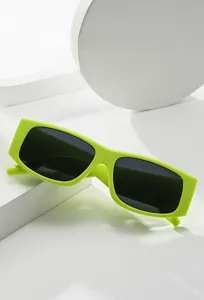 Detail of neon green rectangle sunglasses with thick frame and dark UV lenses