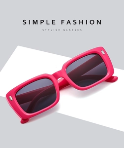 Detail einer pinken rechteckigen Sonnenbrille mit Metallnieten und dunklen Gläsern