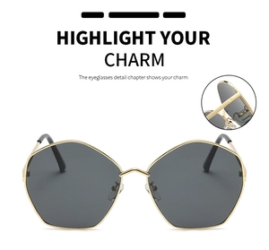 Close-up of golden polygon metal frame sunglasses with precise hinge detail and grey lenses