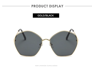 Detail of geometric polygon sunglasses featuring a gold metal frame and dark black lenses