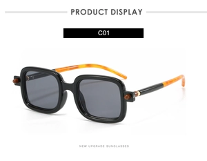 Détail de lunettes de soleil carrées rétro avec branches léopard et charnières en métal