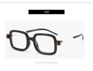 Détail de lunettes de soleil carrées noires avec branches bicolores et accents ronds marron