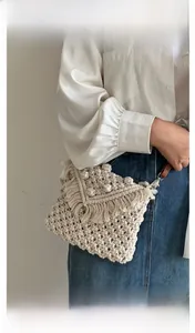 Detailed macro view of bohemian hand-woven cotton bag texture and layered tassels