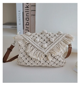 Close-up of bohemian woven cotton bag with tassels, 3D dot patterns and leather strap