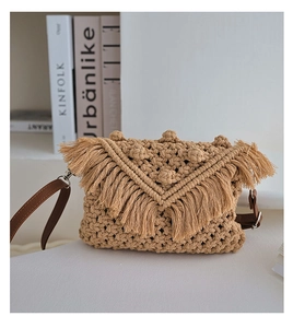 Detail of hand-woven beige crossbody bag featuring V-shaped fringes and brown leather strap