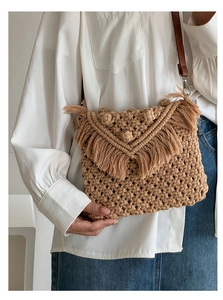 Detail of bohemian woven crossbody bag with cotton fringes and 3D textured ball accents