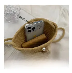 Vue de dessus de l'intérieur du sac seau en paille avec étui pour téléphone et portefeuille