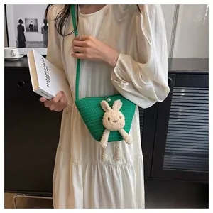 Détail du sac seau au crochet vert avec décor lapin en peluche et bouton perle
