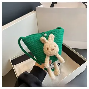 Détail du sac bandoulière vert tissé main avec lapin en peluche et fermoir perle chic