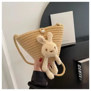 Gros plan détaillé d'un sac en paille tissée avec lapin peluche et fermoir en perles