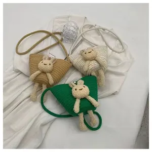 Détail de sacs seaux tissés avec décorations d'animaux en peluche et bandoulière corde
