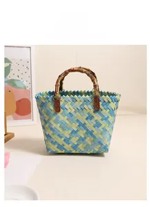 Detail of colorful woven straw bag with vintage bamboo handles and faux leather straps
