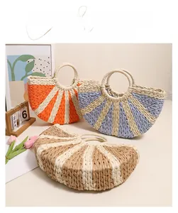 Detailed view of woven straw handbags in color-block designs and circular handles