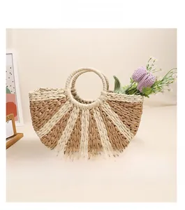 Detail showing semi-circle woven straw handbag with brown striped pattern and round handles