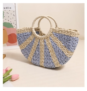 Detail of a semi-circular woven straw handbag with blue and beige stripes and tulip accents