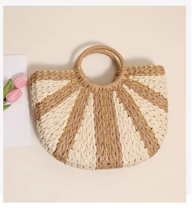 Detail of hand-woven straw tote with golden thread accents and stripes on flat background
