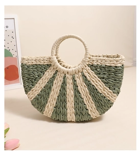 Detail of semi-circle woven straw bag with green contrast stitching and round handles