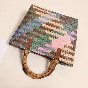 Handmade woven colorful straw tote bag with retro bamboo handles for summer beach vacations