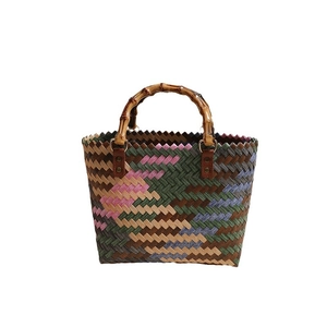 Colorful handmade woven straw tote bag with natural bamboo handles and retro geometric pattern