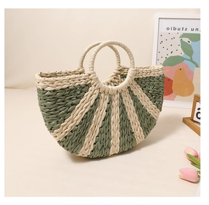 Detail of a semi-circular woven straw handbag with sage green and cream radial stripes