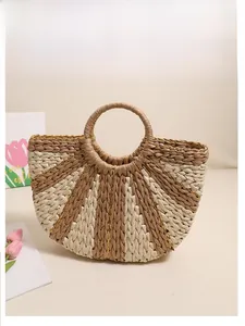Detail of semicircular straw handbag with gold thread accents and striped weaving