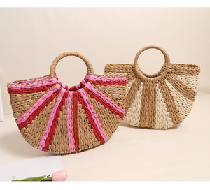 Close-up of semi-circular straw handbags with pink stripes and circular woven handles