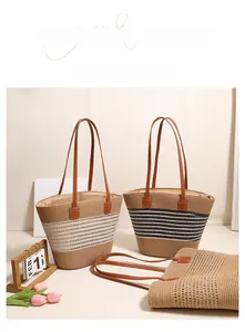 Detail view of woven straw tote bags with black and white stripes and leather handles