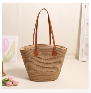 Detailed view of striped woven straw tote with premium brown leather handles for beach
